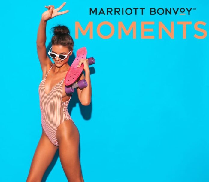 Fröhliche Frau mit Skateboard in der Hand in einer Event von Marrior Bonvoy Moments